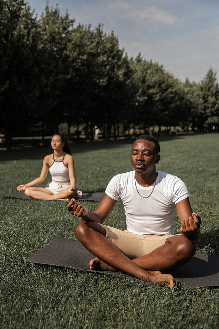 man and woman meditating outside